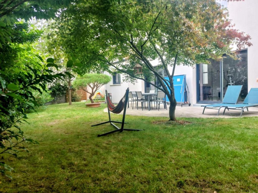 - un hamac installé dans l'herbe dans une cour dans l'établissement Maison 6 personnes, proche Nantes, à Treillières