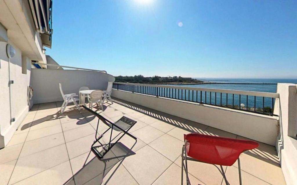 d'un balcon avec des chaises et une vue sur l'océan. dans l'établissement Studio vue mer grande terrasse, à La Grande Motte
