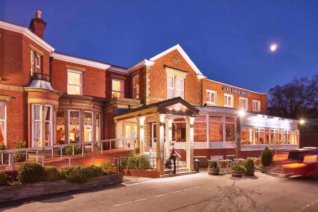 a man walking in front of a brick building at Alma Lodge Hotel in Stockport