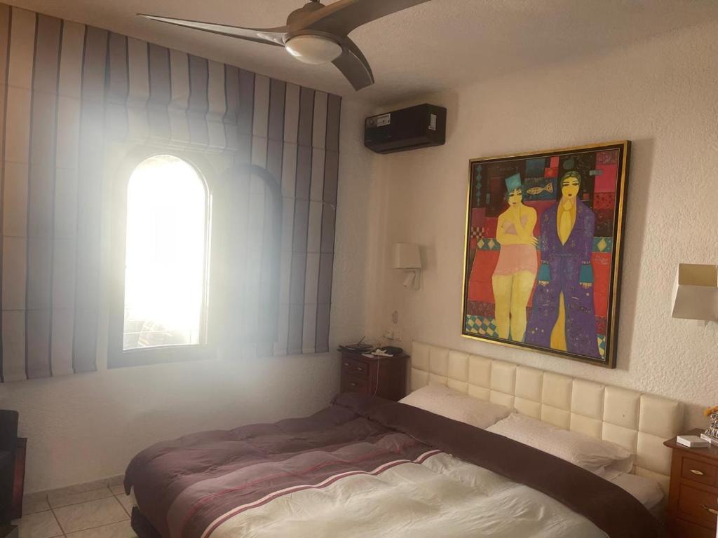 una camera da letto con un letto e un quadro sul muro di Bahia Smir a Dar Merah Deriba