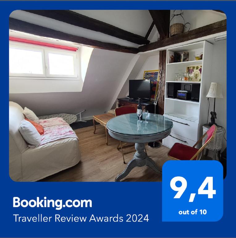 un salon avec une table et un canapé dans l'établissement Appartement Cœur de Paris avec vue sur les toits, à Paris