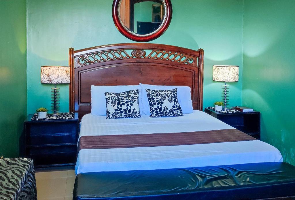 ein Schlafzimmer mit einem großen Bett und einem Spiegel in der Unterkunft RedDoorz at Dream Haven Bed & Breakfast in Valencia