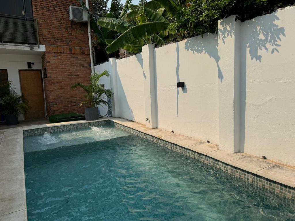 una piscina junto a una valla blanca en Casa Privada con Piscina y Parking Gratis en Asunción, en Asunción