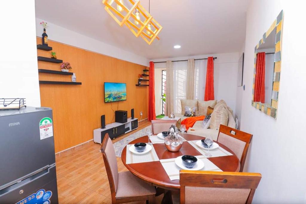 a living room with a table and a dining room at The Gem-3 Bedroom Kiambu Road-Best Rated in Nairobi