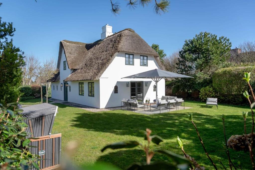 a white house with a thatched roof at Kampenherz - Traumhaftes Einzelhaus im Herzen von Kampen in Kampen