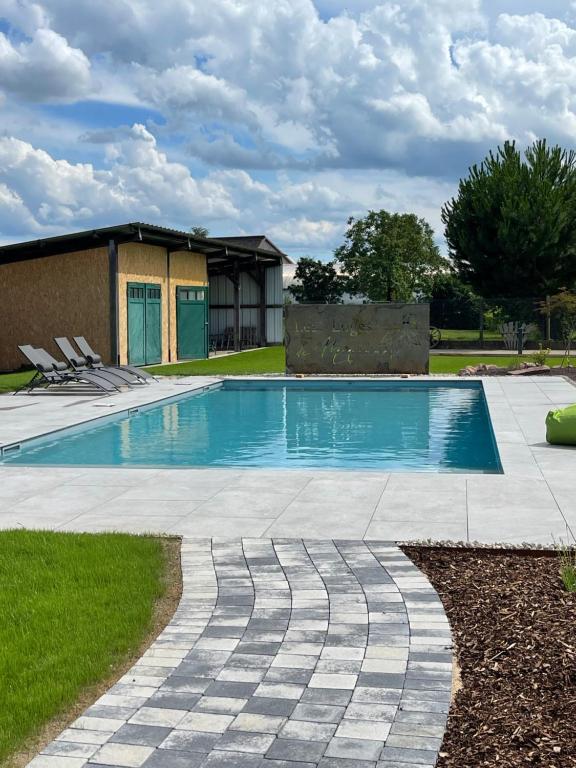 une piscine dans une cour avec une maison dans l'établissement Les loges de Marianne, gites d'exception proche Europapark, à Schoenau