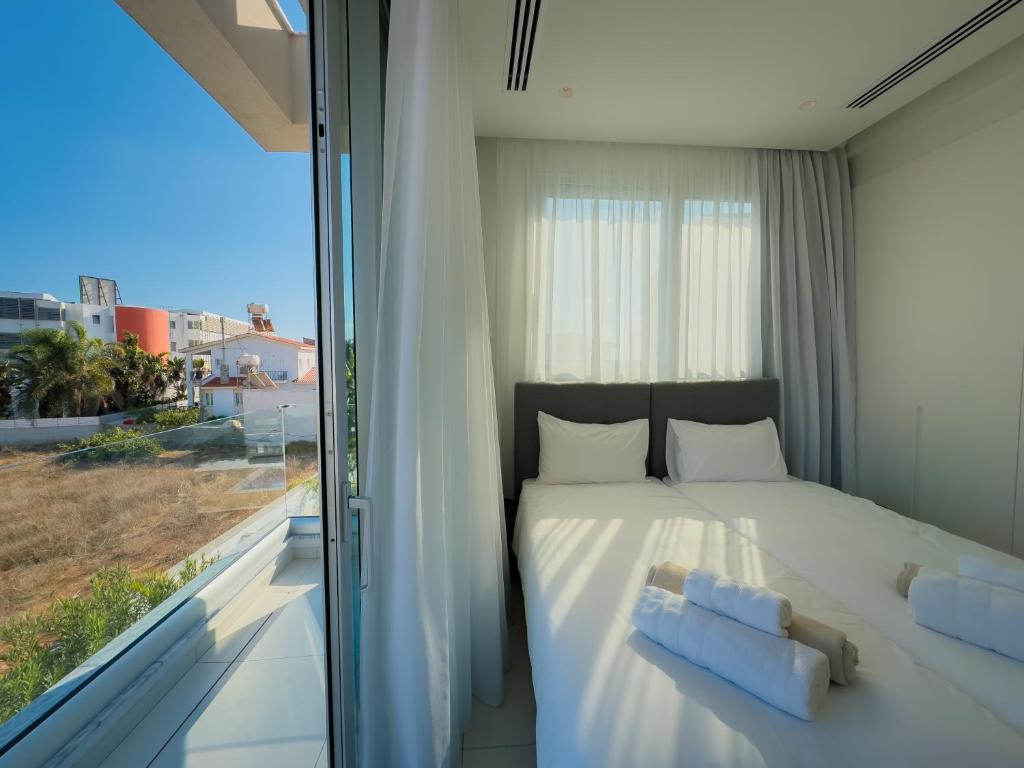 a bedroom with a bed and a large window at City Napa Seaview Villas in Ayia Napa