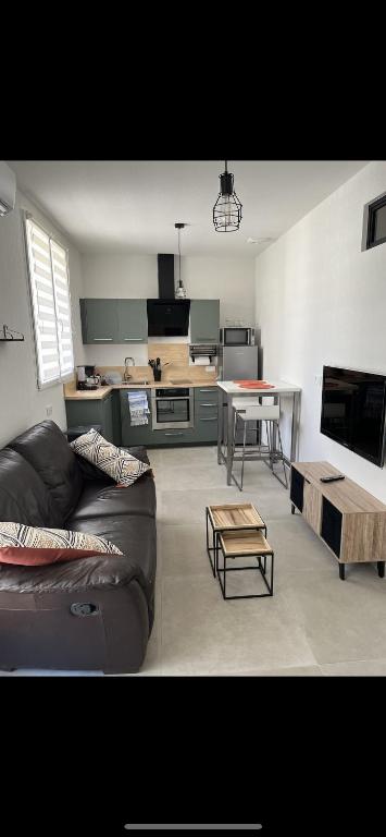 un salon avec un canapé et une table dans l'établissement Superbe appart neuf et cosy, à Agde
