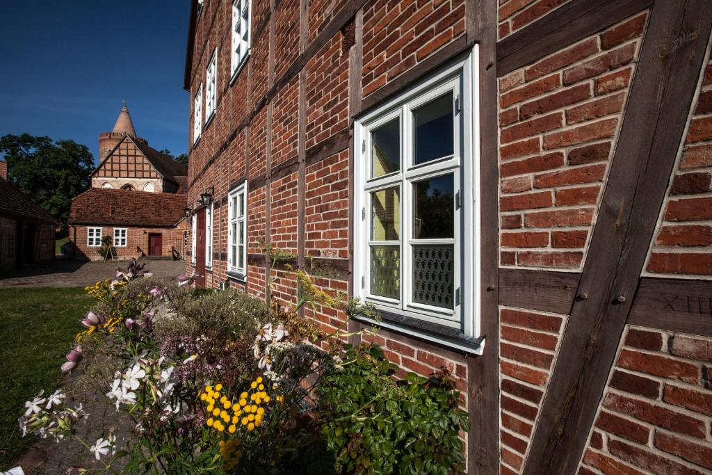 um edifício de tijolos com uma janela e flores em Burghotel Stargard em Burg Stargard