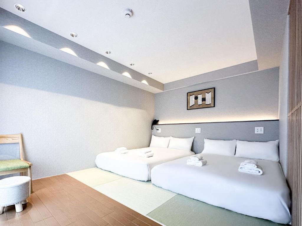 a bedroom with two white beds in a room at Osaka Ebisu Hotel in Osaka