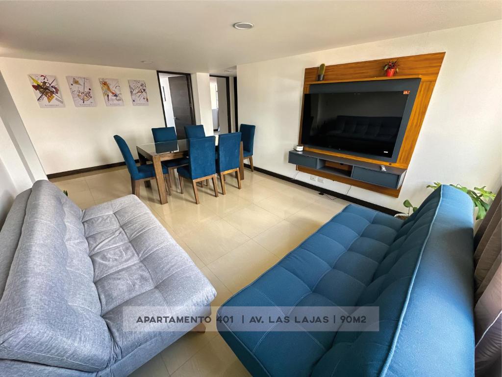 a living room with a blue couch and a tv at Apto 401 / Av. Las Lajas in Ipiales