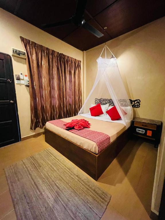 a bedroom with a bed with red pillows at Ombak Dive Resort Perhentian Island in Perhentian Islands