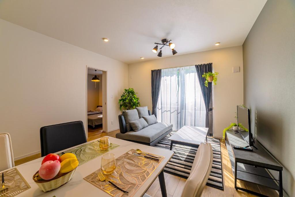 a living room with a table and a couch at 無料レンタカー付 ReHaQ宮古島バケーションレンタルハウス in Miyako Island