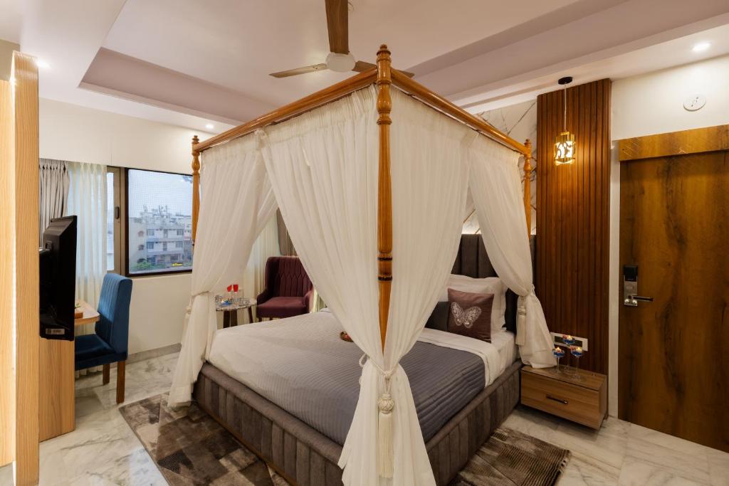 a bedroom with a canopy bed and a television at Hotel Sarang Palace - Boutique Stays in Jaipur