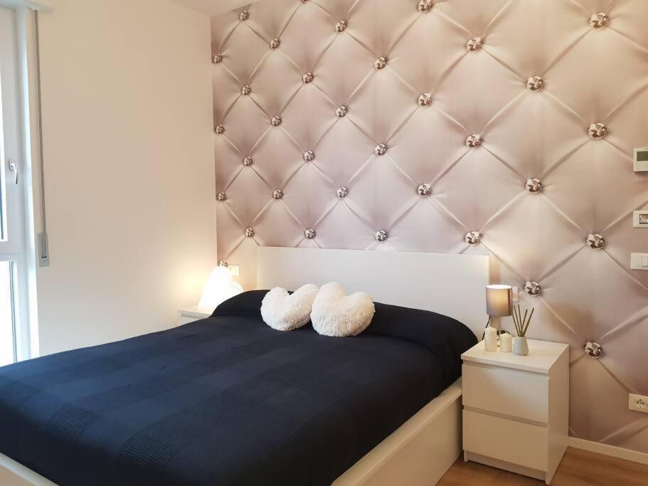 sypialnia z niebieskim łóżkiem i 2 ręcznikami w obiekcie Bsuites trieste in centro storico con wifi w Padwie