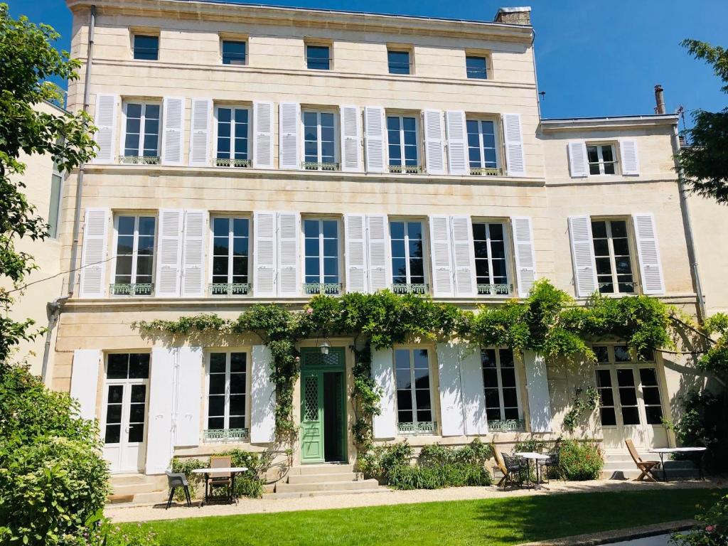 a large white house with a green door at L'Hôtel Particulier du 12 in Niort