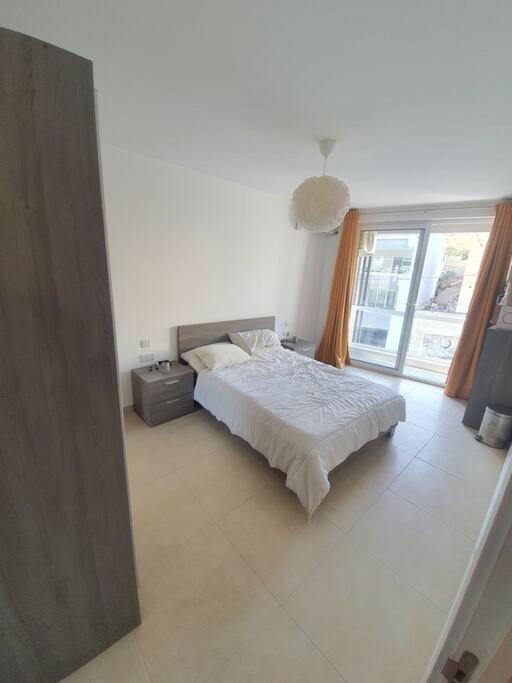 une chambre blanche avec un lit et une fenêtre dans l'établissement Prime Area 1 Bed Apt St Julians, à San Ġiljan