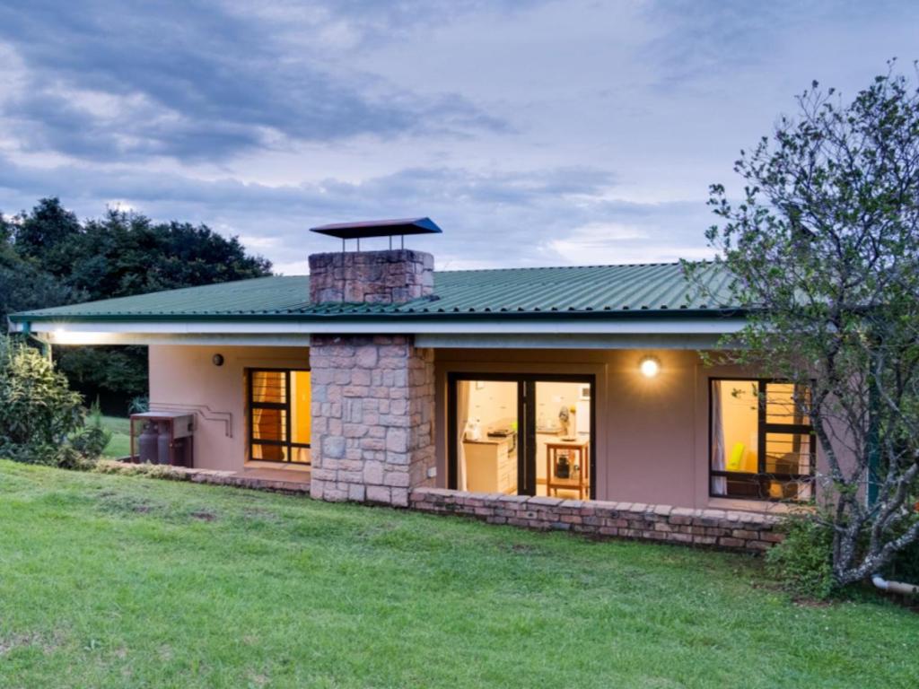 a house with a brick chimney on top of it at Drakensberg Vultures View in Cathkin Park