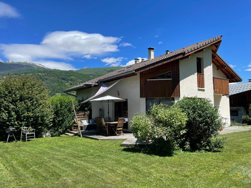 une maison avec une table et des chaises dans une cour dans l'établissement Maison au cœur de la vallée de Haute-Tarentaise, à La Plagne Tarentaise