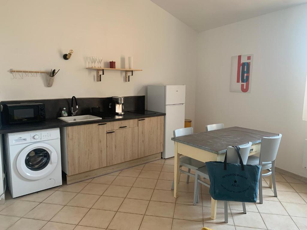 une cuisine avec une table et une machine à laver dans l'établissement Appartement centre-ville Arles, à Arles