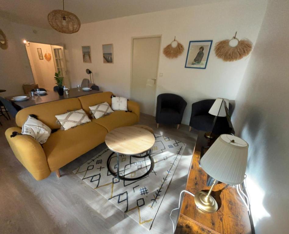 un salon avec un canapé et une table dans l'établissement Appartement en centre ville avec cour face au parc pasteur, à Orléans