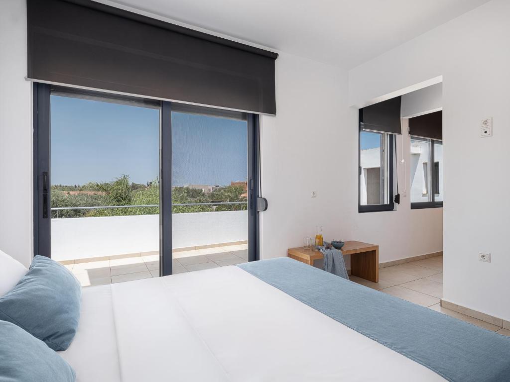 Un dormitorio con una cama blanca y una ventana grande. en Seametry Villa, en La Canea