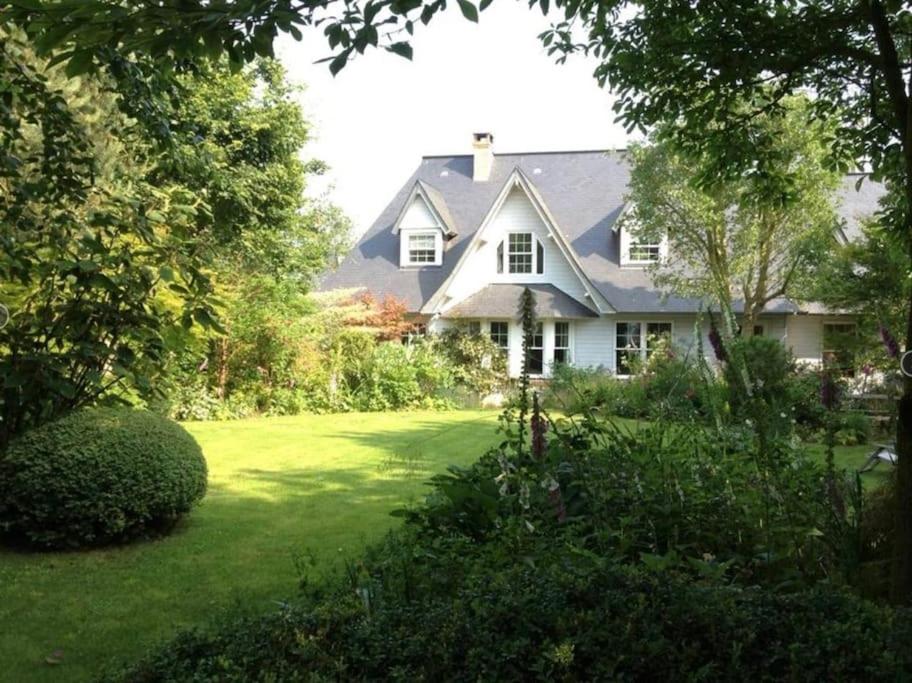 une maison blanche avec une cour avec de l'herbe verte dans l'établissement Séjour paisible maison de charme, à Gueutteville-les-Grès