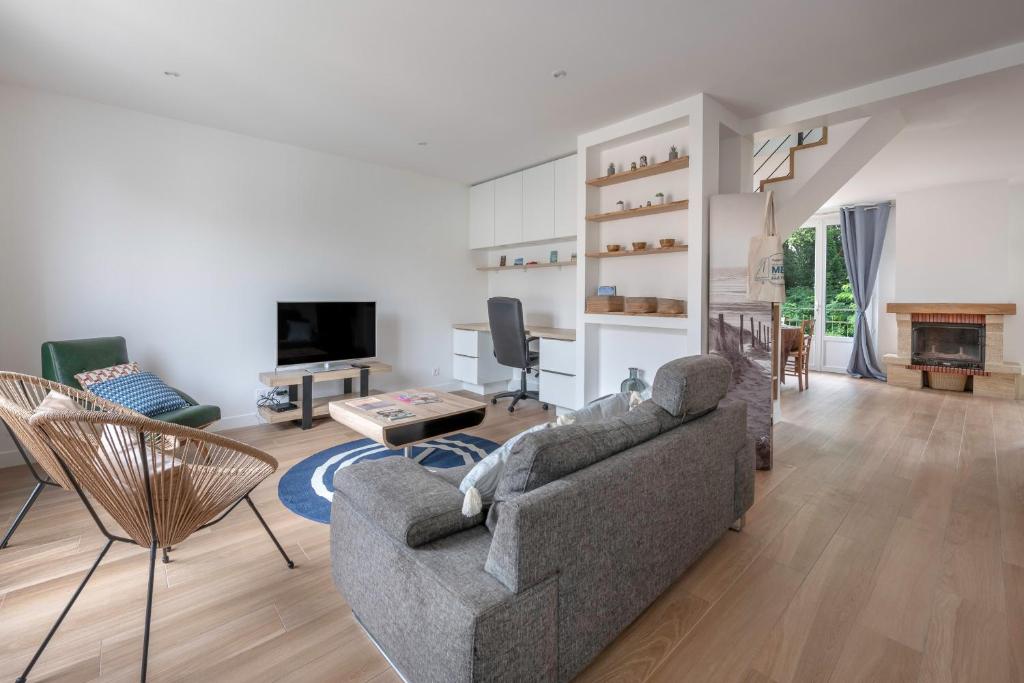 a living room with a couch and a tv at Maison et jardin, 600m de la mer, St Brevin in Mindin