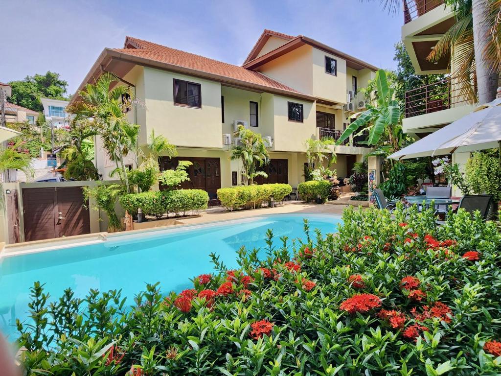 a hotel with a swimming pool in front of a building at Soleil D'asie Residence in Chaweng Noi Beach