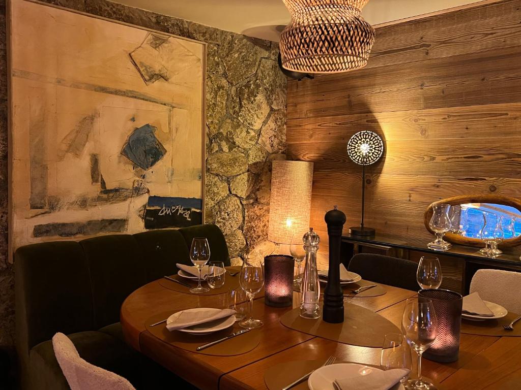 a dining room with a wooden table with wine glasses at Everest Hotel in Val-d'Isère