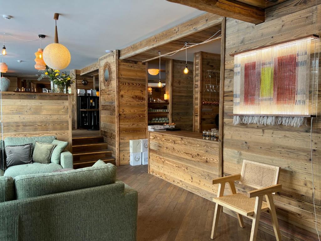 a living room with wooden walls and a couch and chair at Everest Hotel in Val-d'Isère