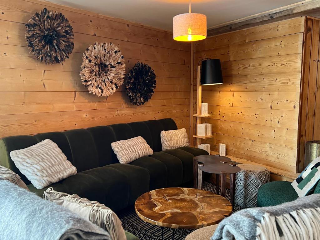 a living room with a black couch and a table at Everest Hotel in Val-d'Isère