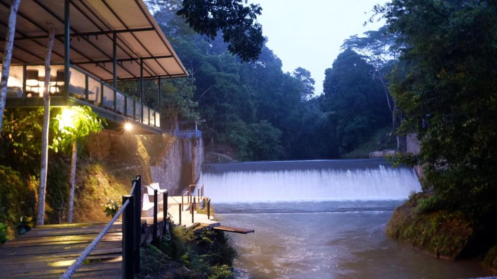 a view of a waterfall with a building and a river at Hau Eco Lodges Citumang Pangandaran in Pangandaran