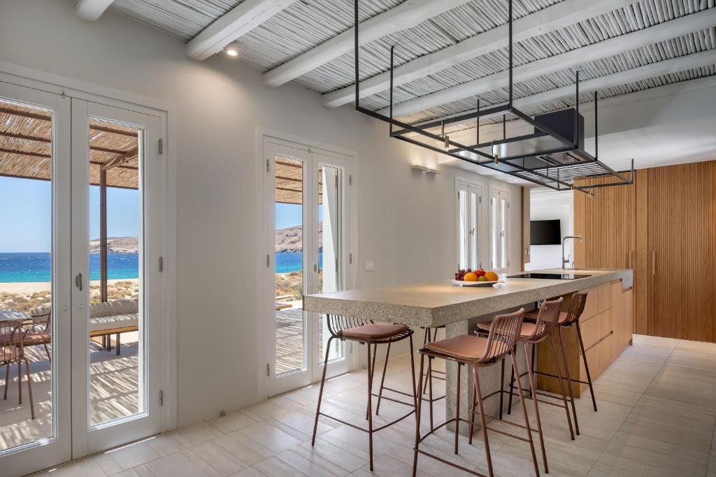 a kitchen with a large island with bar stools at Ammoa Beach Residences in Vayiá