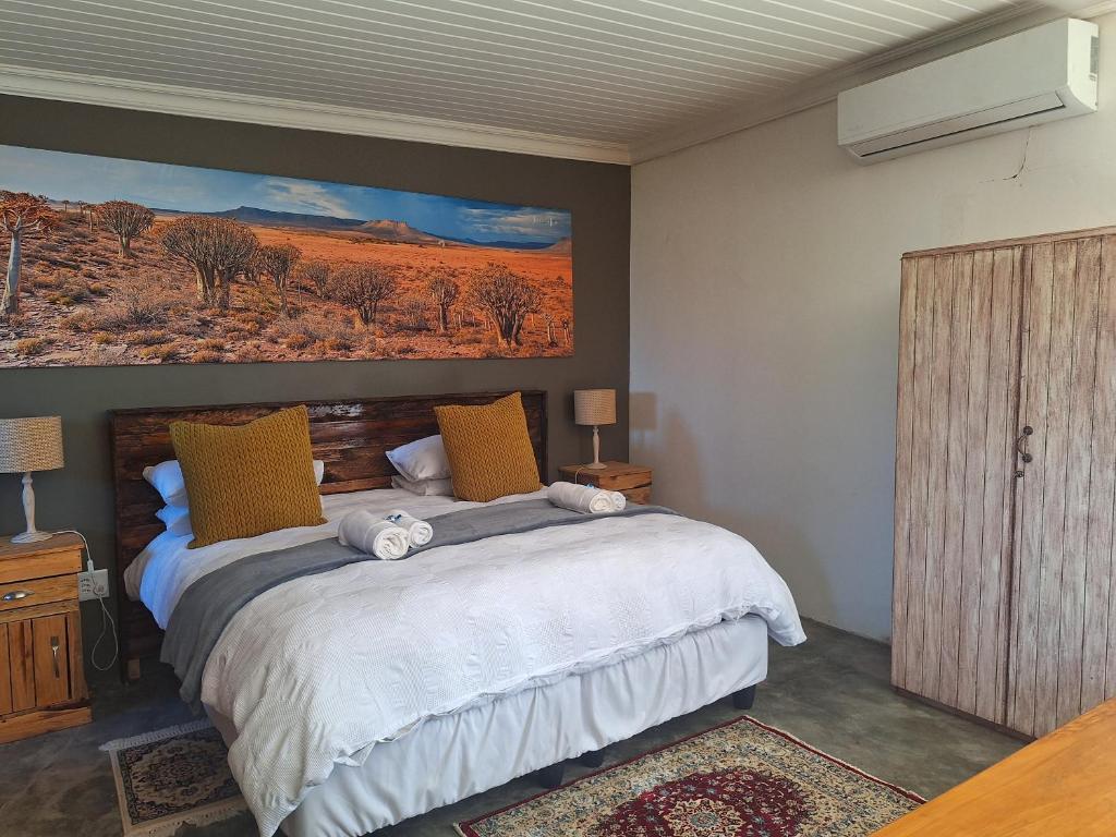 a bedroom with a bed with a painting on the wall at RuaWilla Guest Cottage in Lutzville