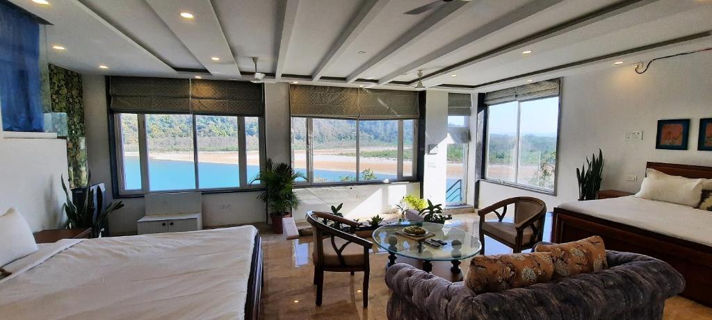 a living room with a table and a bed and a bedroom at Meeram Ganga, A Heritage Stay by the Ganges at Triveni Ghat in Rishīkesh