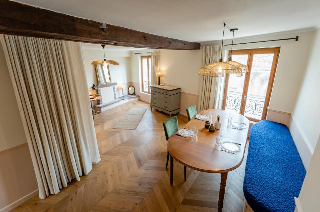 - un salon avec une table et un tapis bleu dans l'établissement Charmant Duplex au Cœur d'Auxerre, à Auxerre