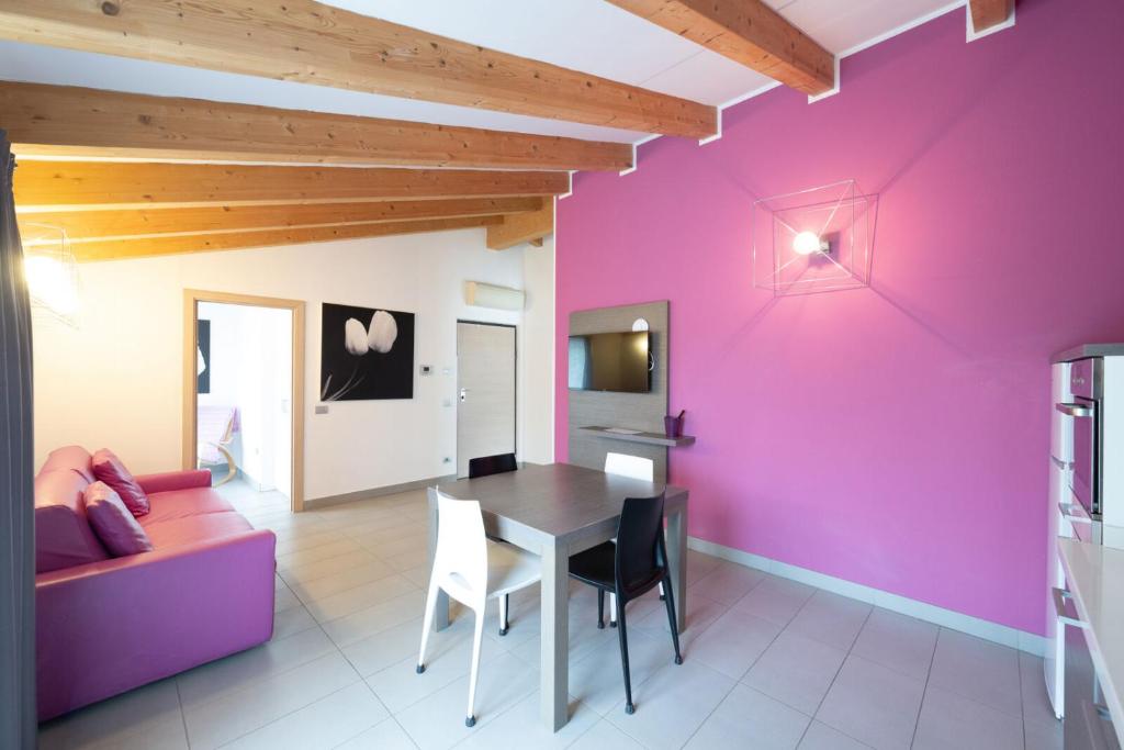 a living room with a table and a purple wall at Residence Desiree in Riva del Garda