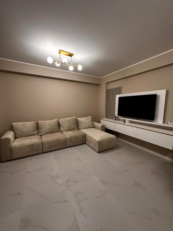 a living room with a couch and a flat screen tv at Luxury apartament in Mamaia Nord