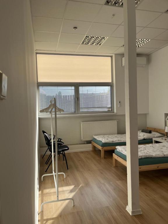 una stanza con due letti e una scrivania di Spacious bungalow with parking a Bratislava