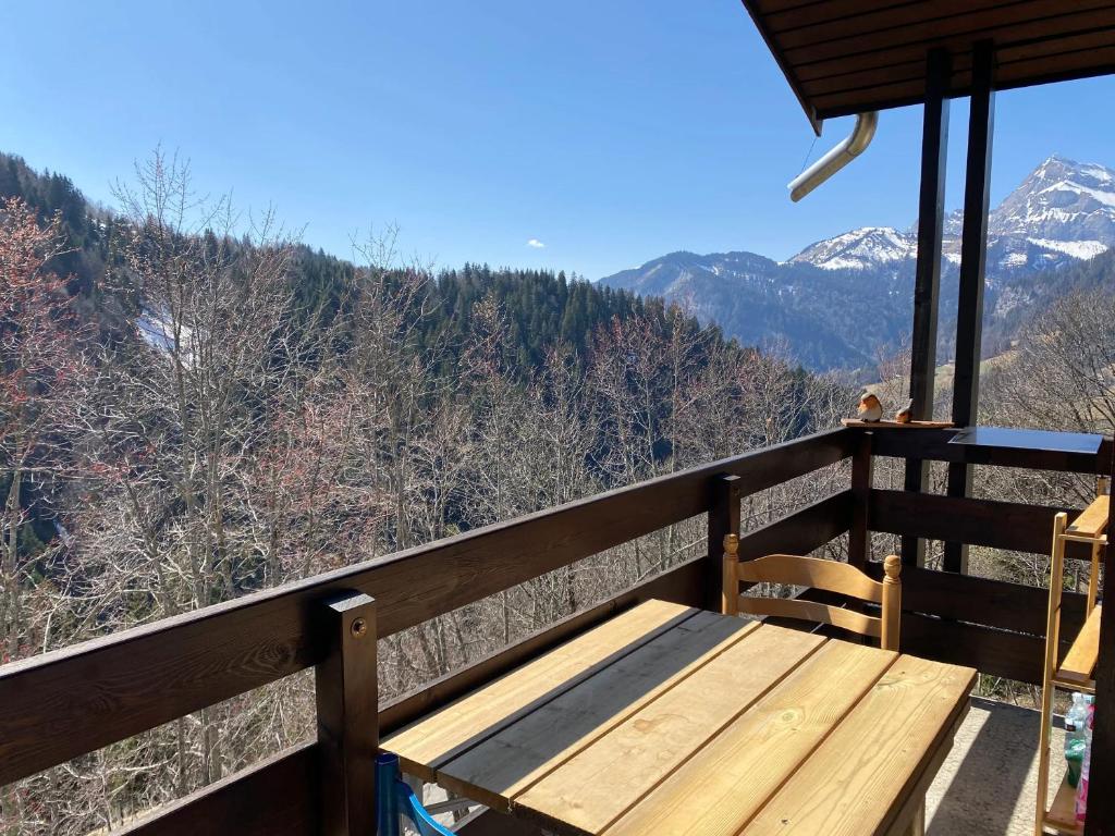 a wooden bench sitting on top of a balcony with mountains at Studio panoramique Notre-Dame-de-Bellecombe - 20 m² - balcon sud in Notre-Dame-de-Bellecombe