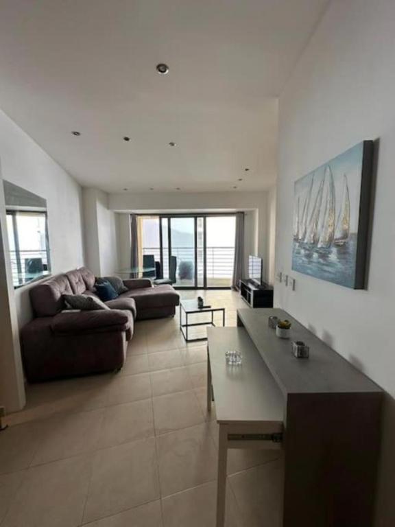 una sala de estar con un sofá y una mesa en Flat in the heart of St Julians, en San Julián