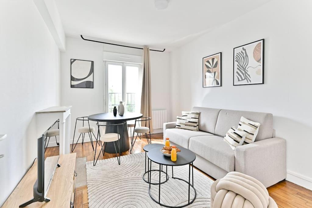 un salon avec un canapé et une table dans l'établissement Havre de paix spacieux en banlieue Parisienne, à Montreuil