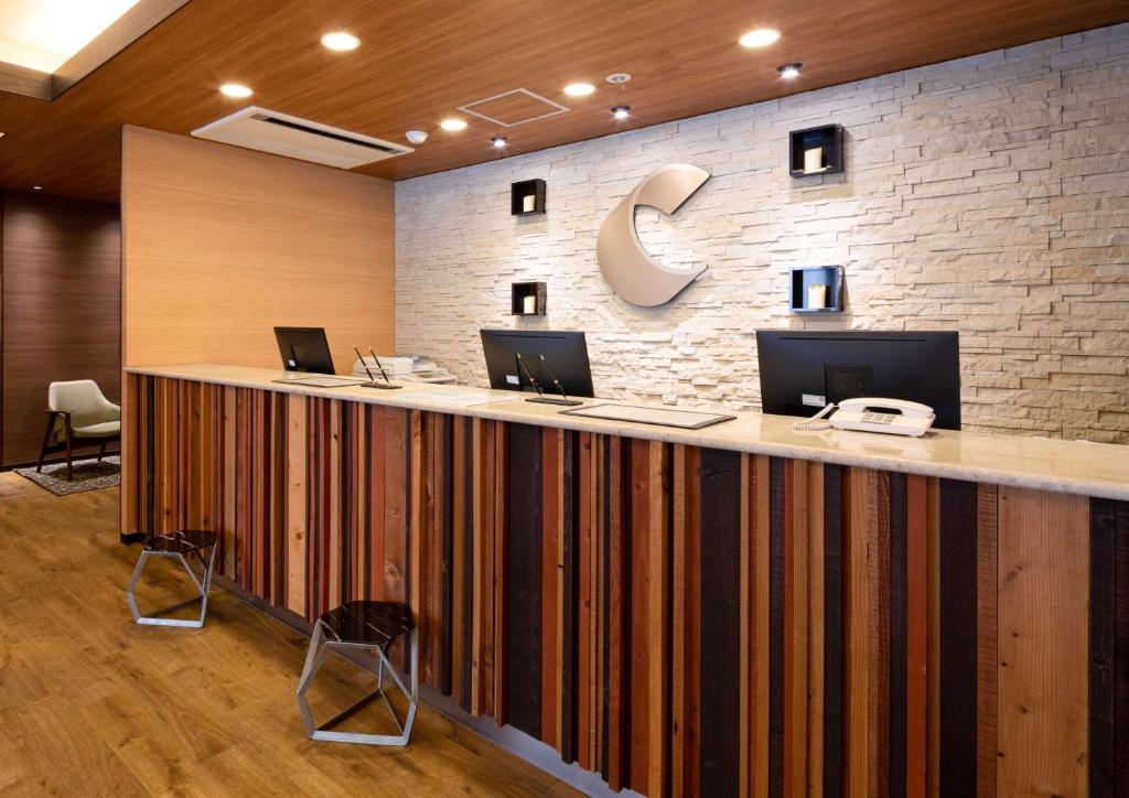 a lobby with a large counter with computers on it at Comfort Hotel Nara in Nara