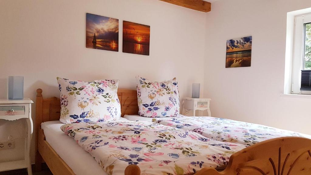 a bedroom with a bed with a floral comforter at Doppelhaushälfte Ostwind vom Naturhof Usedom in Bannemin