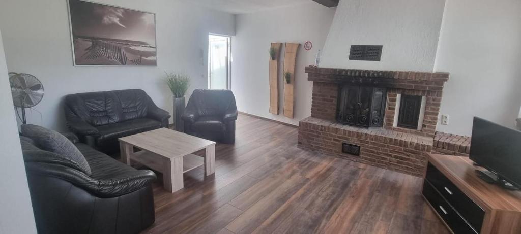 a living room with a couch and a fireplace at Workers Apartments Satzvey in Satzvey