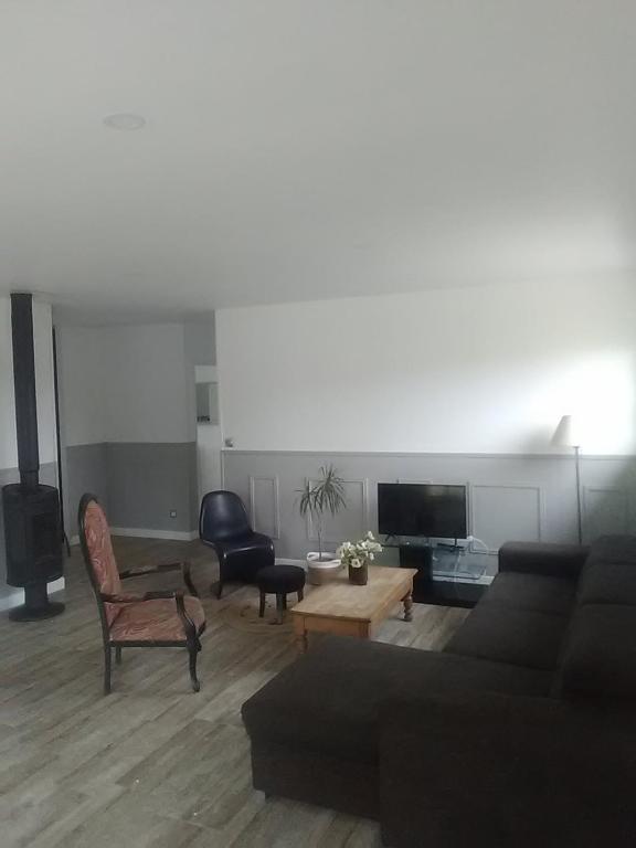 un salon avec un canapé et une télévision dans l'établissement Maison neuve tout confort Soulac sur Mer, à Soulac-sur-Mer