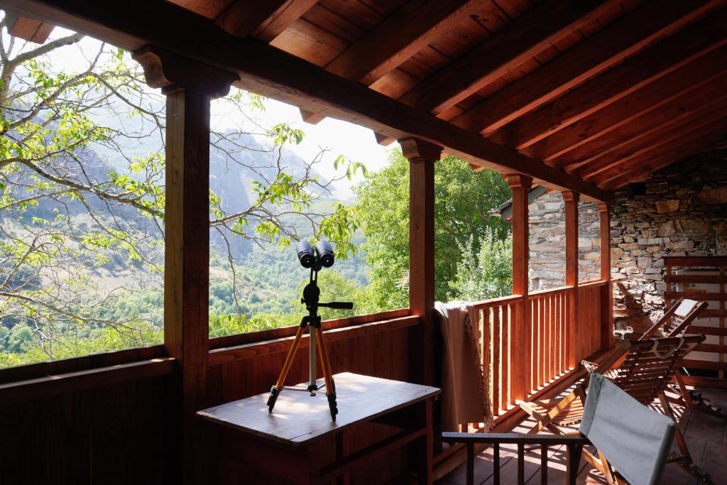 a camera on a tripod on a porch with a view at Fogar Mozárabe in Peñalba de Santiago