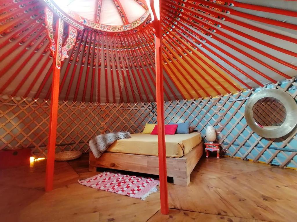 - une chambre dans une yourte avec un lit dans l'établissement Yourte Mongole Aux nuits insolites d'Argoumbat, à Beaumont-de-Lomagne