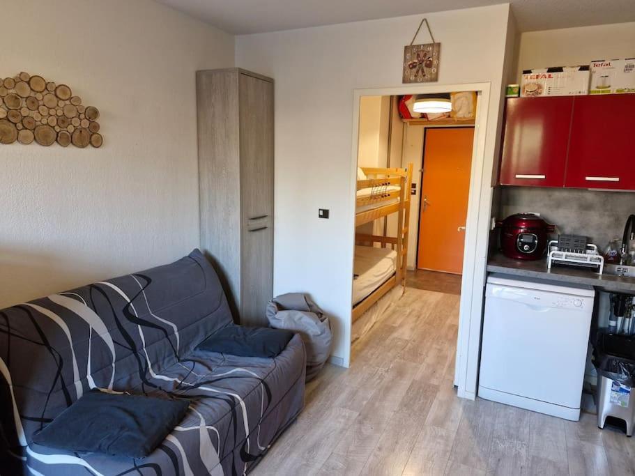 un salon avec un canapé et une cuisine dans l'établissement Appartement au pied des pistes, à La Joue du Loup